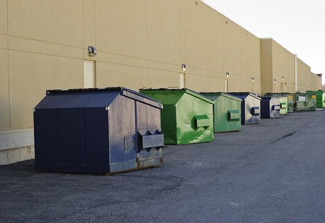 construction workers throw waste into a dumpster behind a building in Apple Valley UT